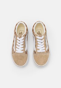 Zapatillas con cordones con una puntera de ante marrón y paneles laterales que presentan un patrón a cuadros en marrón y beige. Cordones blancos y suela de goma.