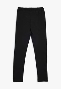Leggings noirs en tissu doux et extensible. Ils présentent une taille élastique et un design moulant sans coutures ni motifs visibles.