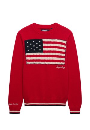Czerwony dzianinowy sweter z dużą naszywką z flagą USA i białym napisem "Superdry" na przodzie, z prążkowanymi mankietami i dołem ze paskami.