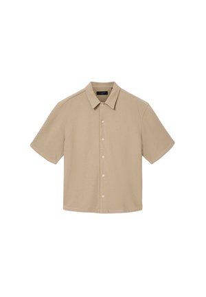 Camicia beige a maniche corte realizzata in tessuto morbido, con chiusura frontale a bottoni e colletto classico. Texture liscia con design semplice e senza motivi.