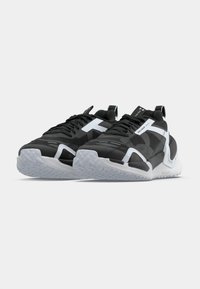 Αθλητικά παπούτσια σε ασπρόμαυρο με υφή στον ε πάνω μέρος, χοντρή λευκή μεσαία σόλα και διαφανές λαστιχένιο πέλμα με σχεδιασμένο πέλμα.