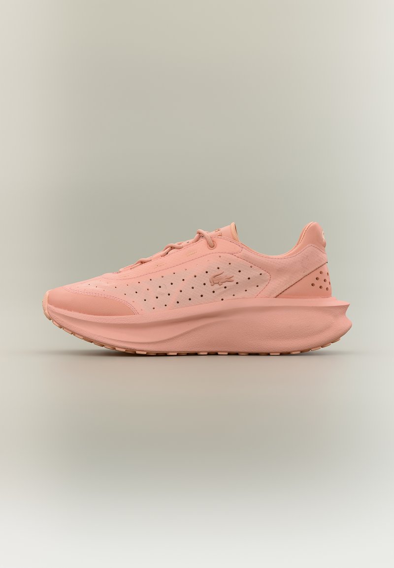Αθλητικό ανοιχτό ροζ παπούτσι με διάτρητο πλαϊνό πάνελ, χοντρή σόλα και διακριτικό λογότυπο, τοποθετημένο σε ουδέτερο φόντο.