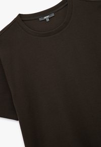 Camiseta de manga corta de canalé color marrón oscuro con diseño de cuello redondo, que presenta una tela texturizada y sutiles detalles de costura.