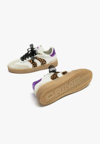 Sneakers bianchi con accenti laterali a stampa leopardo, tacchetti viola sul tallone, lacci di raso neri e suole in gomma impresse con la scritta "CRIME."