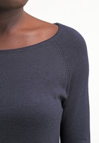 Pull en tricot bleu marine avec un large décolleté et des manches longues, présentant des détails côtelés subtils le long des coutures et de l'ourlet.