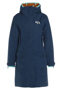 Marineblaue wasserdichte Parka mit Kapuze, türkisen Akzenten, zwei Vordertaschen und einer gesteppten Innenfutter. Logo auf der Brust sichtbar.