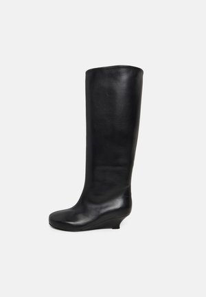 Stivale nero in pelle fino al ginocchio con tacco a zeppa basso e punta leggermente arrotondata, mostrato su sfondo bianco semplice.