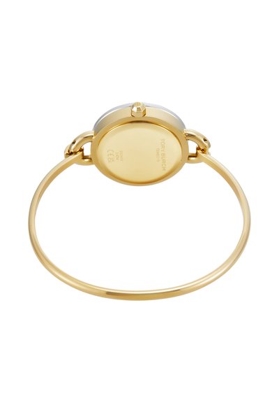 Montre bracelet ronde ton or avec un bracelet rigide fin et des détails de la marque gravés au dos du boîtier de la montre.