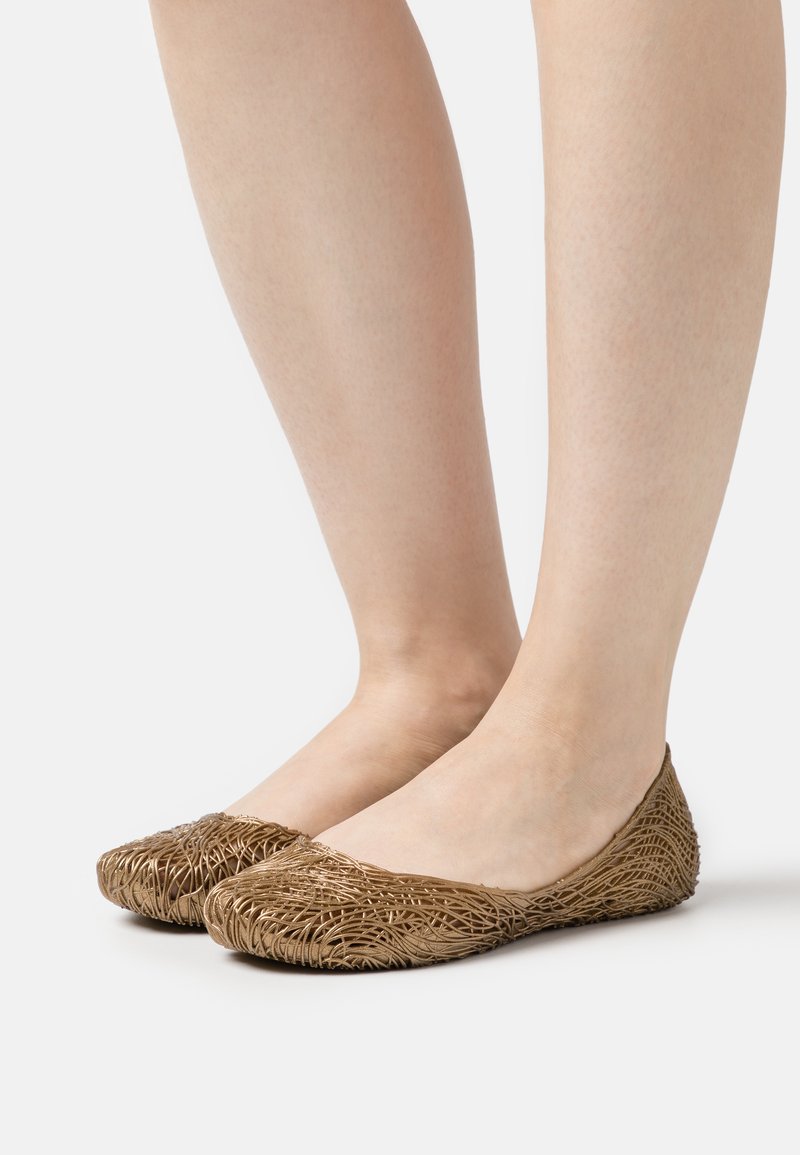 Ballerine marroni realizzate in materiale intrecciato. Punta rotonda con una forma flessibile. Il design presenta una superficie testurizzata con motivi intricati.