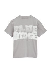 Pelēka īsām piedurknēm T-krekls ar lielu balto "BLUE RIDGE" grafiku, kas attēlo kalnus. Audums šķiet gluds un viegls.