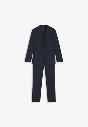 Laivansinis paltas, sudarytas iš vieno sagos, su atitinkančiomis kelnėmis, su subtiliu langeliais ir lygia tekstūra.