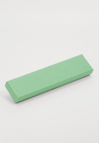 Embalagem rectangular verde com um acabamento texturizado, apresentando bordas anguladas e um logótipo em relevo subtil, colocada sobre um fundo branco.