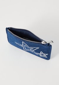 Denim coin pouch, dark blue with silver star design, zip closure, and smooth texture. Interior lined with dark fabric. Compact rectangular shape.