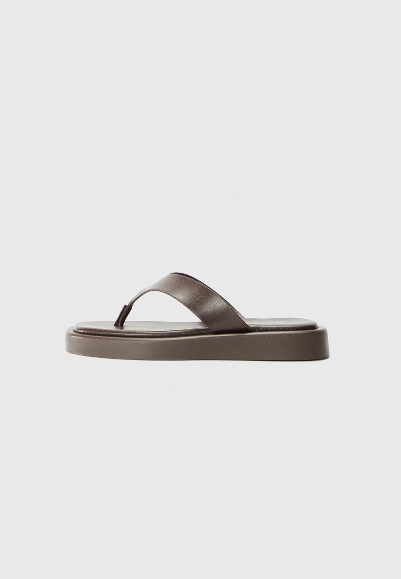 Brune lær flip-flop med en slank rem og tykk såle. Designet har en glat tekstur og en let glans, som giver et minimalistisk udseende.