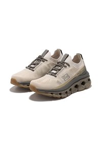 Zapatillas deportivas beige con parte superior de malla texturizada, cordones grises estrechos, acentos grises y una suela acolchada distintiva con un diseño único.