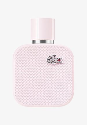 Rosa rektangulär parfymflaska med strukturerad yta med diamantmönster och ett silverlock. Har en liten broderad krokodil-logotyp.