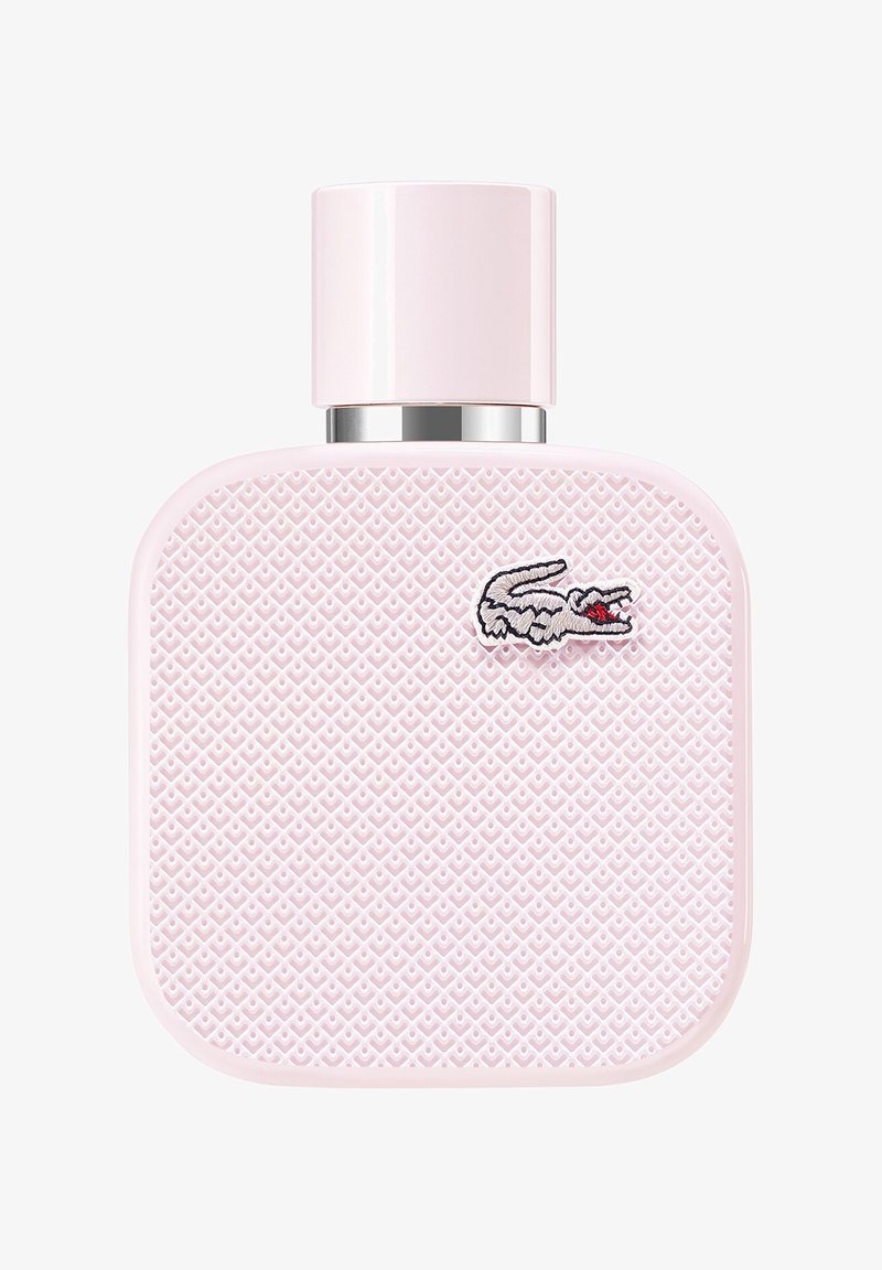 Rosa rektangulär parfymflaska med strukturerad yta med diamantmönster och ett silverlock. Har en liten broderad krokodil-logotyp.