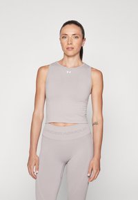 Lys grå sports tanktop med en tettsittende design, flate sømmer og en kort lengde, kombinert med matchende høytlivs tights med logo detaljer.