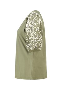 Olijfgroene top met korte mouwen, voorzien van een textuur met witte floral geborduurde patronen op een mouw, gemaakt van zachte stof en in een relaxte pasvorm.