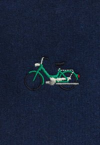 Navyblauwe stof met een klein geborduurd fietsontwerp in groene, witte en zwarte draad, met een rode accenten aan de achterkant.