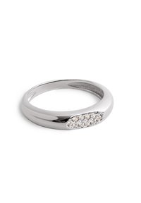 Anillo de banda de plata con una superficie lisa y un conjunto de piedras preciosas transparentes dispuestas en un diseño ovalado en un lado.