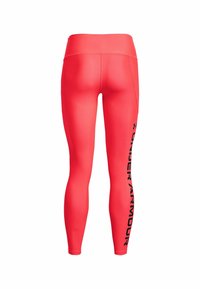 Czerwone dopasowane legginsy wykonane z elastycznego materiału. Posiadają szeroki pas i czarne logo po lewej stronie. Gładka tekstura, aerodynamiczny kształt.