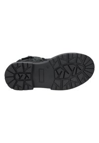 Suela de calzado negra texturizada que presenta un patrón de tracción robusto con ranuras profundas para mayor agarre y un borde liso para mayor durabilidad.