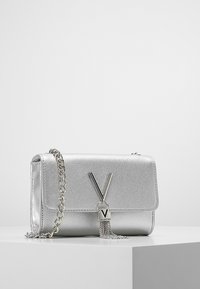 Borsa a tracolla in pelle argento con finitura texturizzata, tracolla a catena, chiusura a pattina magnetica e un prominente logo "V" con un dettaglio a nappa.