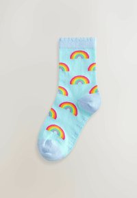 Calcetines de color azul claro con un patrón de arcoíris coloridos. Textura suave, puño acanalado y área del dedo del pie en azul claro.