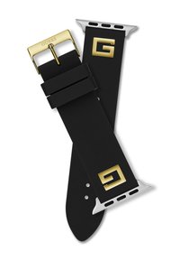 Correa de reloj de silicona negra con accesorios dorados, que presenta el logotipo "GUESS" en la hebilla y un acento plateado cerca de la zona de conexión.