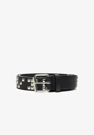 Ceinture en cuir noir avec des clous carrés en argent et une boucle en métal argenté, enroulée sur un fond blanc.