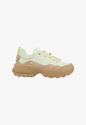 Lacoste sneakers featuring a beige rubber sole, cream upper textile with mesh accents, and neon green highlights on the laces and heel.