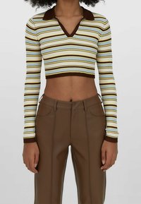 Krótki top z długimi rękawami, wzór w pionowe paski w kolorach żółtym, niebieskim i brązowym, prążkowana faktura oraz brązowy kołnierz. Dobierz brązowe spodnie.