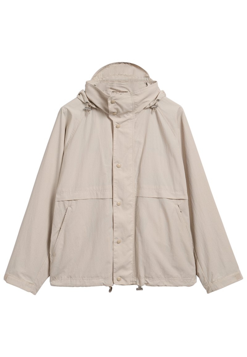 Veste légère beige avec capuche, fermeture à boutons-pression, deux poches avant et cordons de serrage ajustables à la capuche et à l'ourlet.