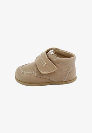 Zapato de bebé de cuero beige con puntera redondeada, cierre de tira Velcro, costuras blancas en contraste y suela de goma blanda.