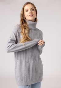 Szary sweter z golfem o splocie warkoczowym, z prążkowanym kołnierzem, wyposażony w dwie przednie kieszenie i luźny krój. Miękka, textured materiał.