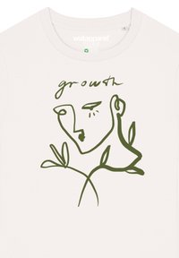 Weißes Baumwoll-T-Shirt mit einer minimalistischen grünen Linzeichnung eines Gesichts und Blättern, mit dem Text "Wachstum" über der Illustration.