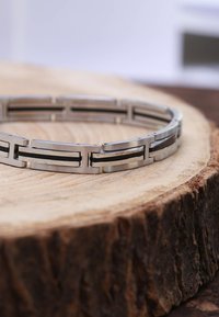 Metalen armband met afwisselend matte en gepolijste secties, met rechthoekige schakels en een glad, plat ontwerp. Grijs en zilver kleuren.