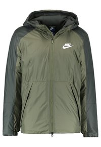 Olivgrön Nike-jacka med dragkedja fram, huva och kontrasterande mörkgröna ärmar. Har en logotyp på vänster bröst och elastiska manschetter.