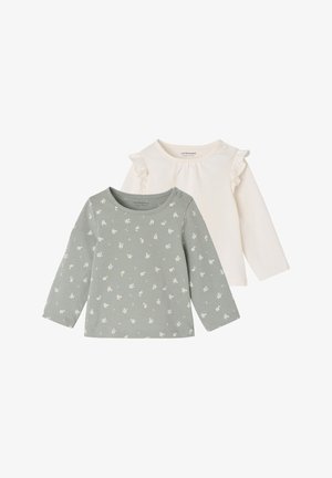 Zwei Langarmoberteile: eines in blassgrün mit weißem Blumenmuster und rundem Ausschnitt; das andere in creme mit Rüschendetails an den Schultern.