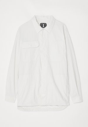 Witte button-up shirt van textuurstof, met een kraag, twee voorzakken en een gebogen zoom met een iets langere achterkant.