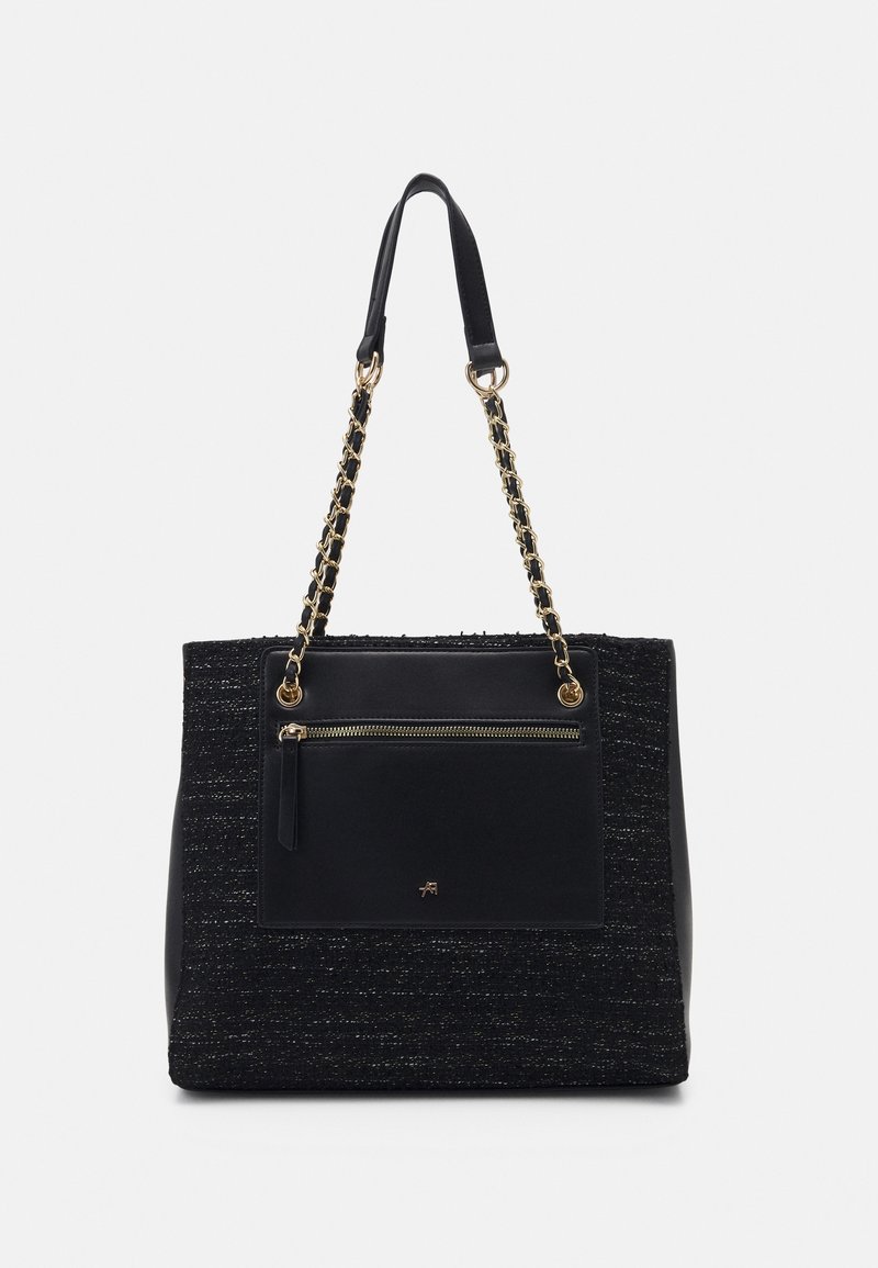 Černá taška přes rameno s tkanou texturou, doplněná zlatými řetízkovými uchy a zipovou přední kapsou. Hladké koženkové lemování kolem okrajů.