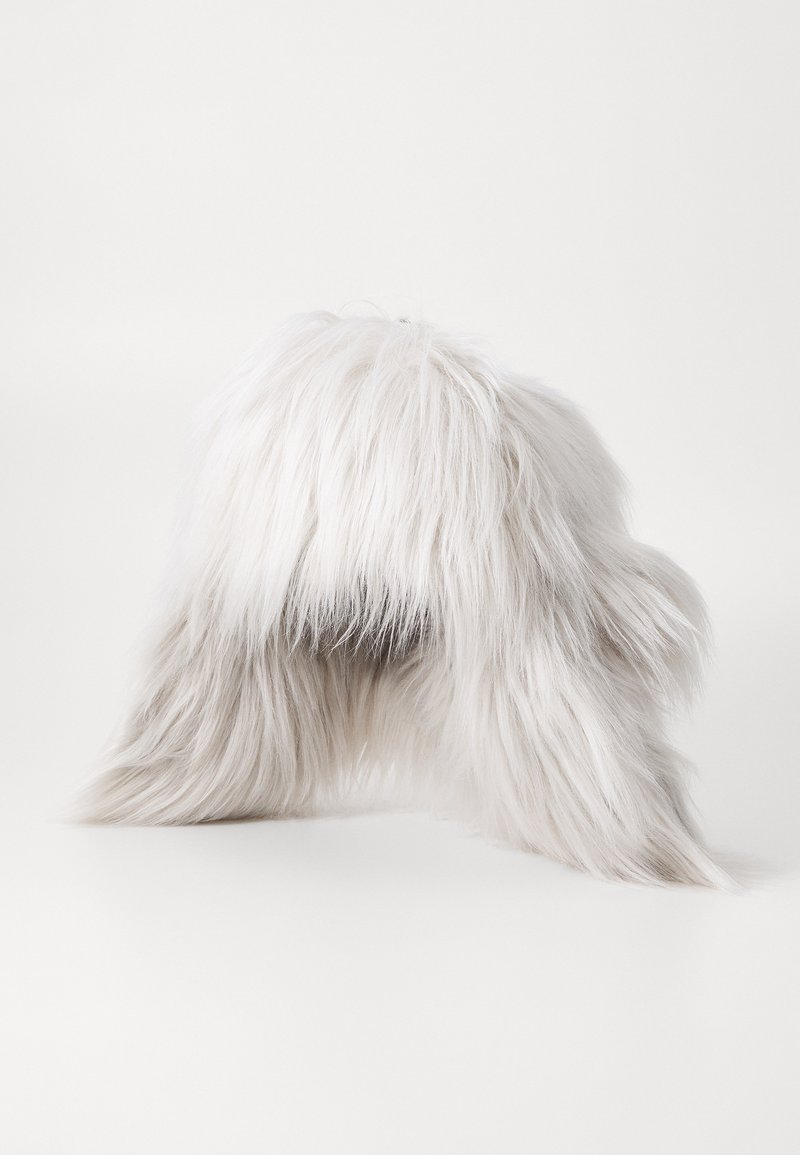 White faux fur hat with long, soft strands, rounded shape, and a textured appearance. The interior is dark, contrasting with the exterior.
