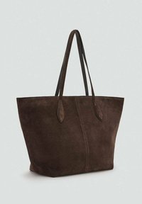 Brązowa zamszowa torba na ramię o szerokim, otwartym kształcie. Posiada dwa ciemno-brązowe skórzane uchwyty i jednolitą konstrukcję. Miękka tekstura, minimalne detale.