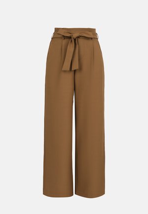 Καφέ παντελόνια σε φαρδιά γραμμή με ψηλή μέση και υφασμάτινη ζώνη δεμένη σε φιόγκο μπροστά, σε απλό φωτεινό φόντο.