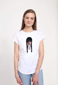 Bílá bavlněná trika s grafikou dívky s copánky a nápisem "NO HUG ZONE" v tučném černém a růžovém písmu.