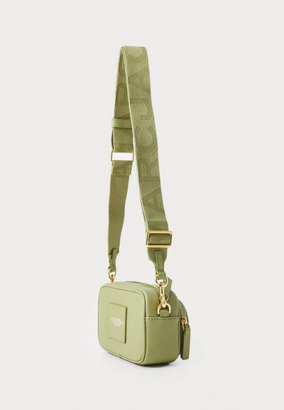 Obdélníková zelená crossbody taška vyrobená z texturovaného materiálu, s kovovým zipem, zlatým kováním a nastavitelným popruhem.