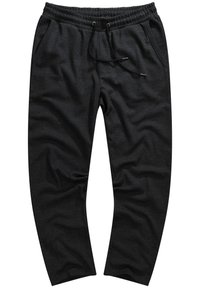 Pantalones jogger negros hechos de tejido texturizado; cuenta con una cintura elástica, cordón y bolsillos laterales.