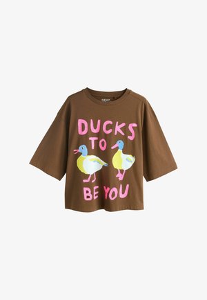Barna rövid ujjú pamut póló, két színes kacsa grafikájával és a "DUCKS TO BE YOU" felirattal rózsaszínben.