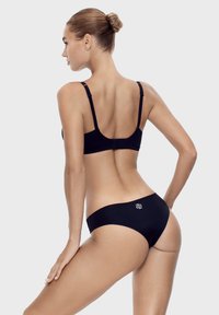 Czarny komplet bikini o prostym fasonie. Góra posiada regulowane ramiączka, a dół jest bezszwowy z małym logo jako akcentem.